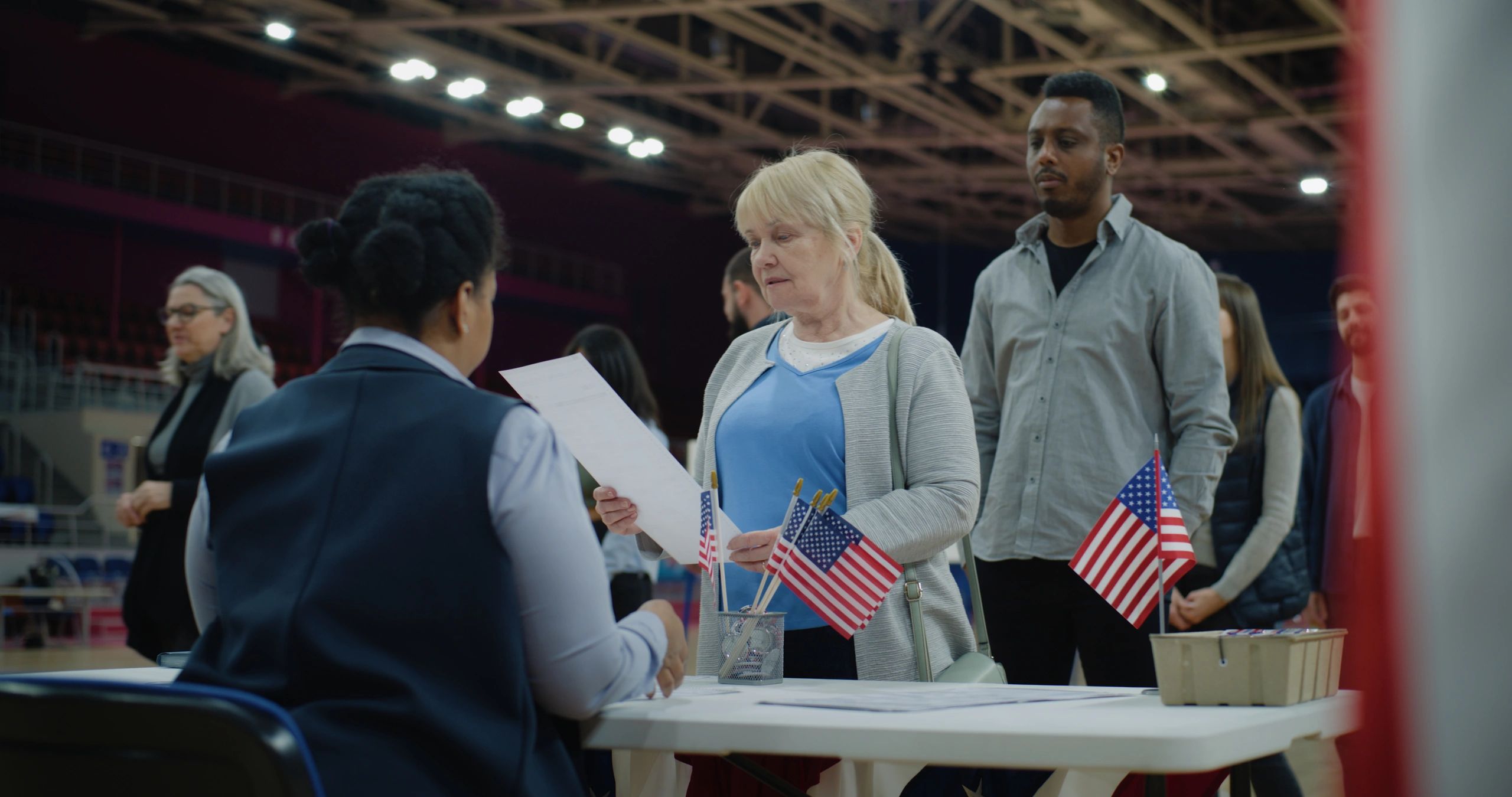 Community member engaging with a civic volunteer at a public polling station