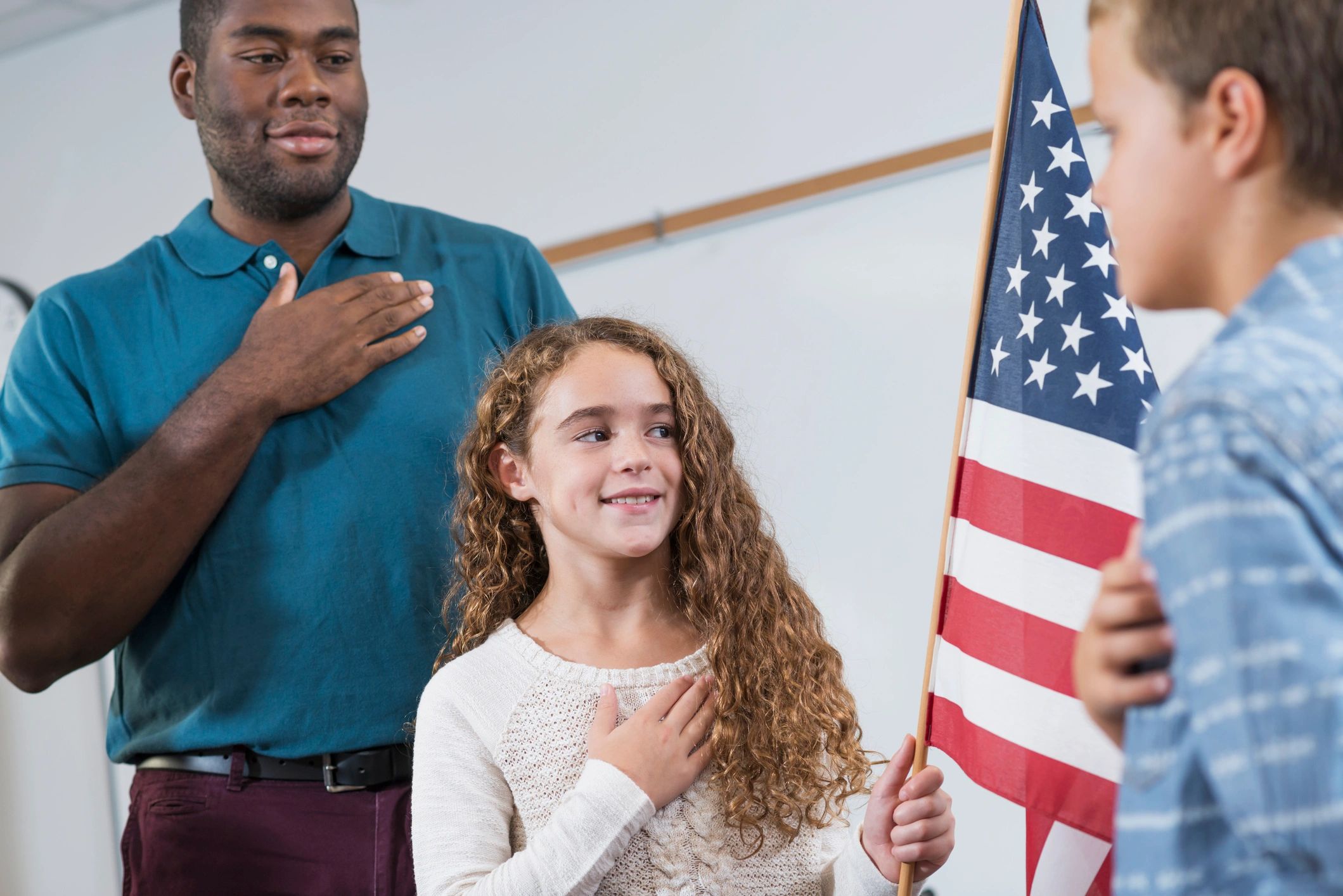 Students and teacher with American flag in a classroom